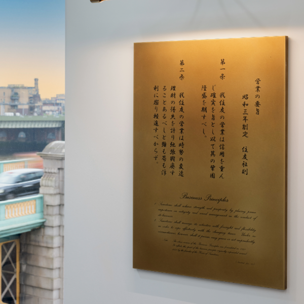 A white wall with a brass bespoke plque featruing chinese language